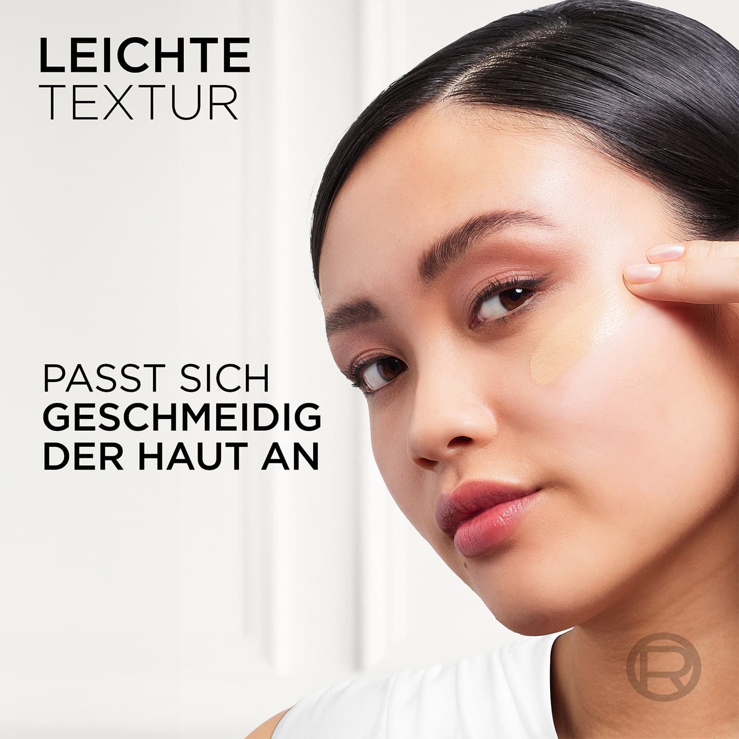 Junge Frau trägt eine Nuance auf ihre Wange auf & Text - leichte Textur, passt sich geschmeidig der Haut an